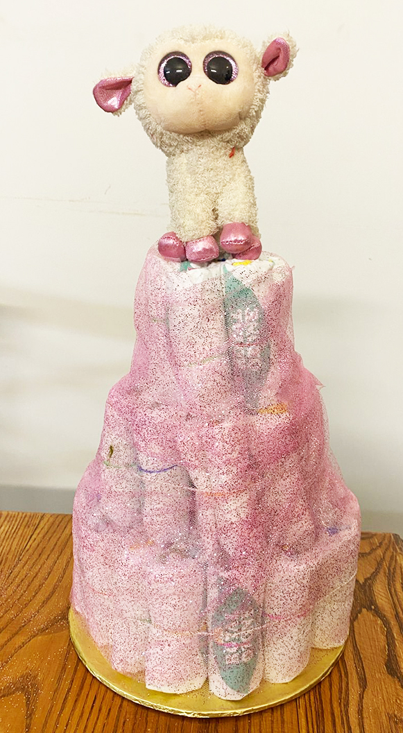 Diaper cake decoration with a soft toy topper